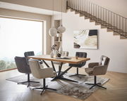 Moderner Essbereich mit einem großen Holztisch und sechs gepolsterten Armlehnstühlen in verschiedenen Farben, seitliche Perspektive.