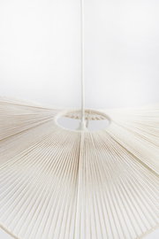 Nahaufnahme einer weißen Hängeleuchte mit fächerförmigem Design, von unten betrachtet.