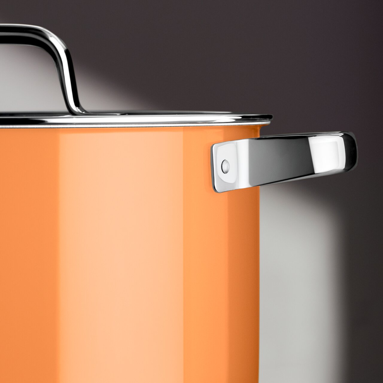 Nahaufnahme eines orangefarbenen Schmortopfs mit Deckel, seitliche Perspektive, zeigt den glänzenden Metallgriff.
