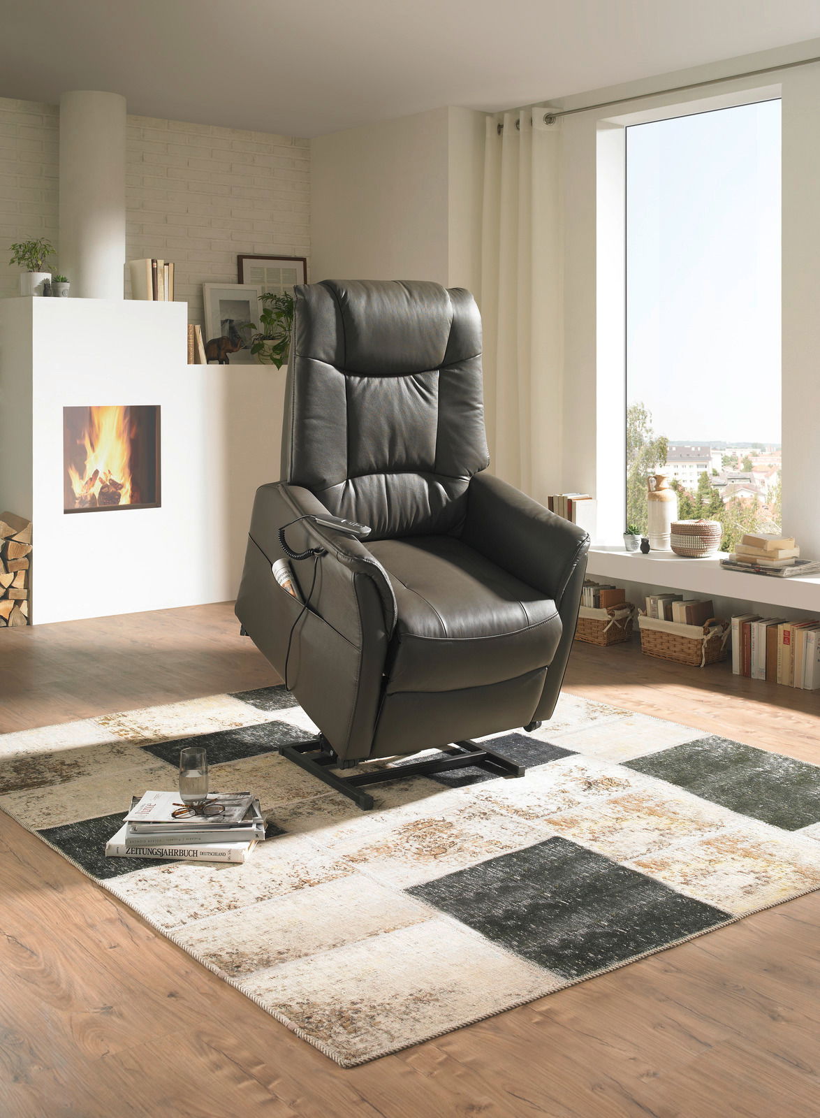 Moderner Fernsehsessel in dunklem Leder, seitliche Perspektive, in einem gemütlichen Wohnzimmer mit Kamin und großem Fenster.
