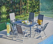 Gartenmöbel-Set mit sechs grauen Klappsesseln und einem Tisch auf einer Terrasse neben einem Pool, umgeben von grüner Vegetation, aus der Vogelperspektive.