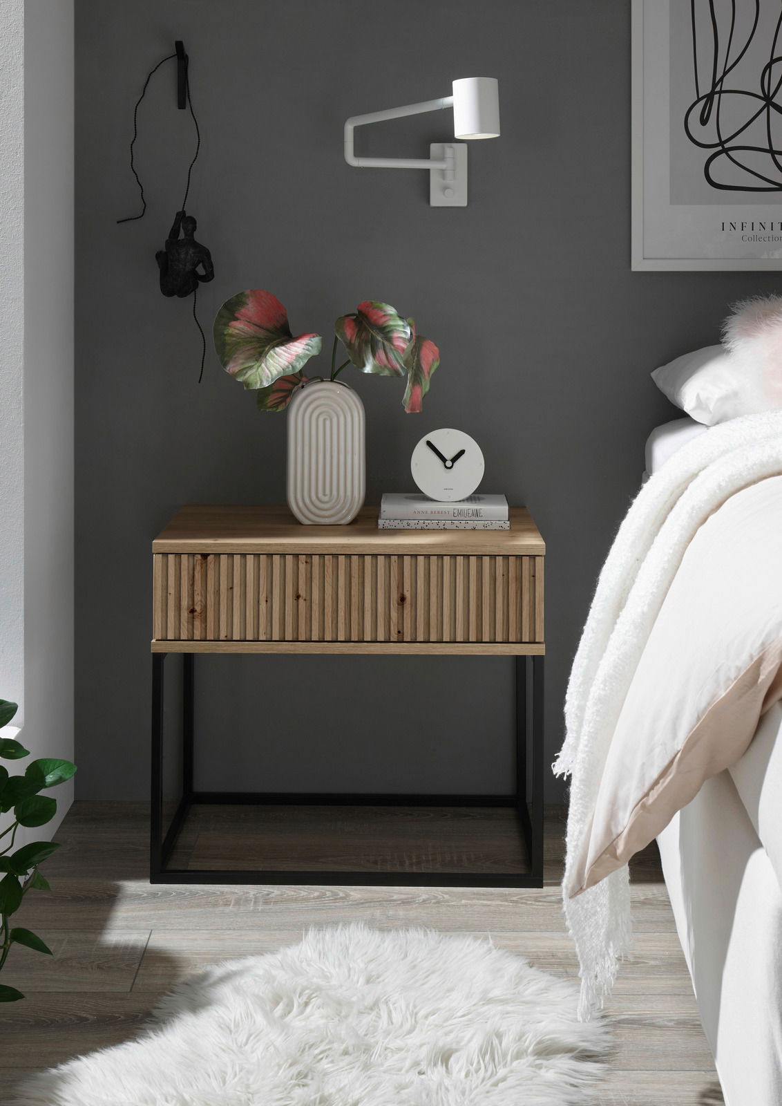 Moderne Nachtkommode aus Holz mit geriffelter Front, schwarzem Metallgestell und dekorativen Elementen, seitliche Perspektive.