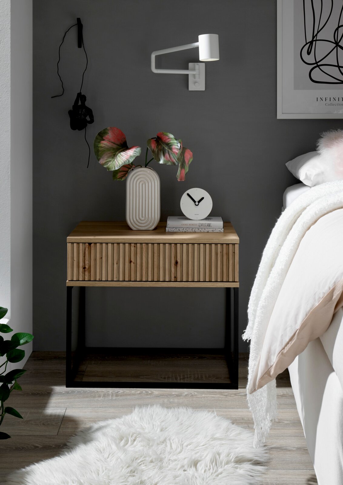 Moderne Nachtkommode aus Holz mit geriffelter Front, schwarzem Metallgestell und dekorativen Elementen, seitliche Perspektive.