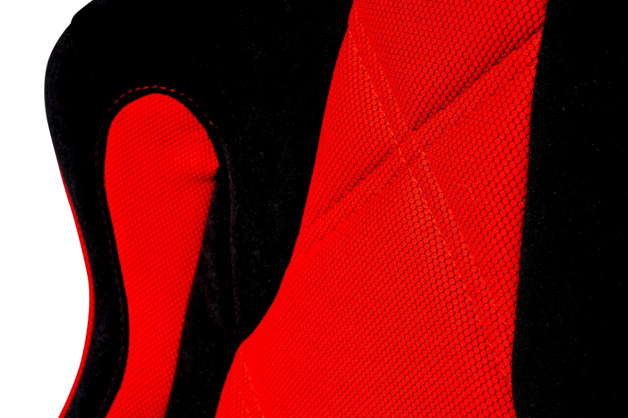 Nahaufnahme eines Gaming-Stuhls mit rotem Netzstoff und schwarzem Polster, seitliche Perspektive.