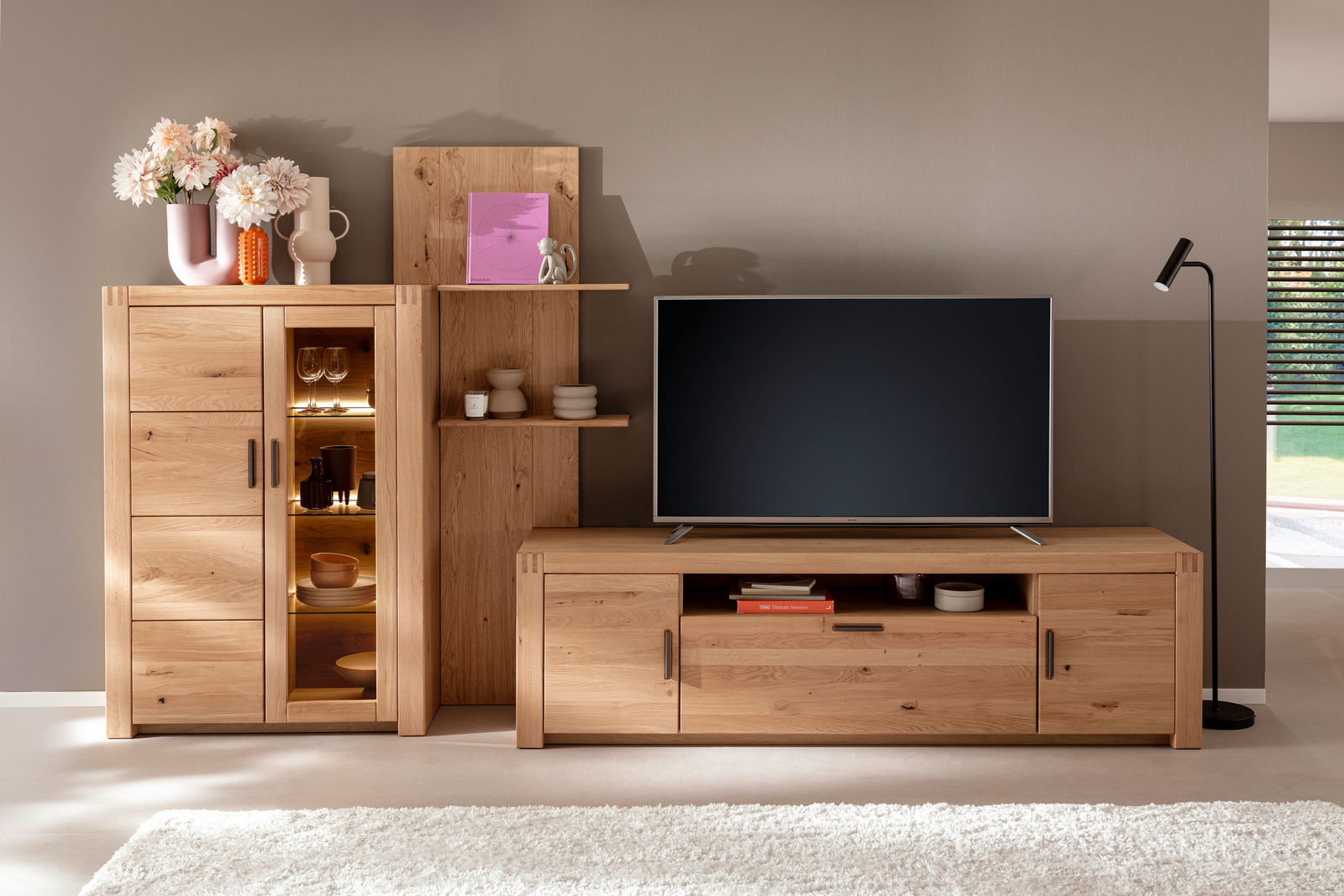 Holz-Wandregal in einem modernen Wohnzimmer, frontal fotografiert, mit Dekorationen wie Vasen und Büchern.