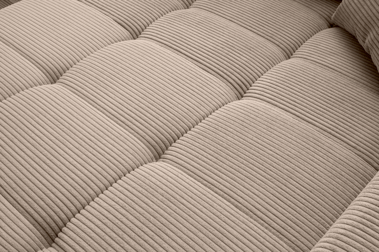 Nahaufnahme einer beige gestreiften Polsteroberfläche mit weicher Textur, perspektivisch von oben betrachtet.