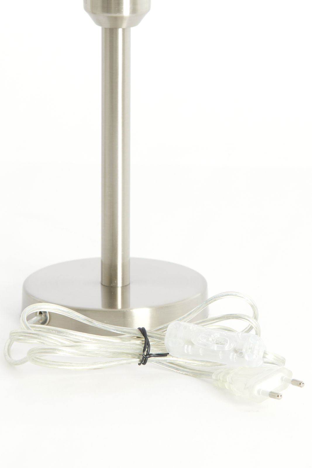 Nahaufnahme eines silbernen Lampenfußes mit rundem Sockel und transparentem Kabel mit Schalter, seitliche Perspektive.