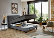 Modernes Boxspringbett in einem stilvollen Schlafzimmer mit geöffneter Bettkastenfunktion, seitliche Perspektive.
