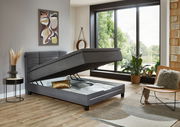 Modernes Boxspringbett in einem stilvollen Schlafzimmer mit geöffneter Bettkastenfunktion, seitliche Perspektive.