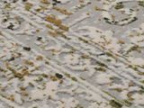 Nahaufnahme eines Designer-Teppichs mit abstraktem Muster in Weiß, Grün und Beige, von schräg oben fotografiert.