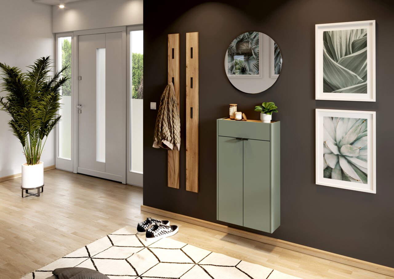 MID.YOU Hängeschuhschrank AMECA Moderner Eingangsbereich mit einem hängenden Schuhschrank in Grün, einem runden Spiegel und dekorativen Pflanzen. Perspektive von der Seite.