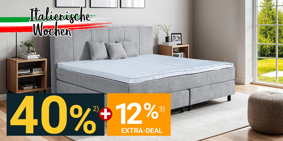 Modernes Boxspringbett in Grau mit Polsterkopfteil im hellen Schlafzimmer mit Fenster und Nachttischen