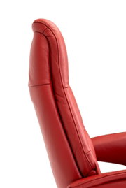 Zijaanzicht van een rode relaxfauteuil met zachte bekleding.