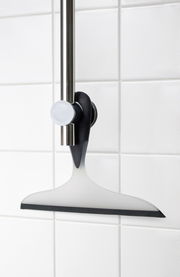 Badezimmerwischer 2K Loano in seitlicher Perspektive an einer Duschstange montiert, vor weißen Fliesen.