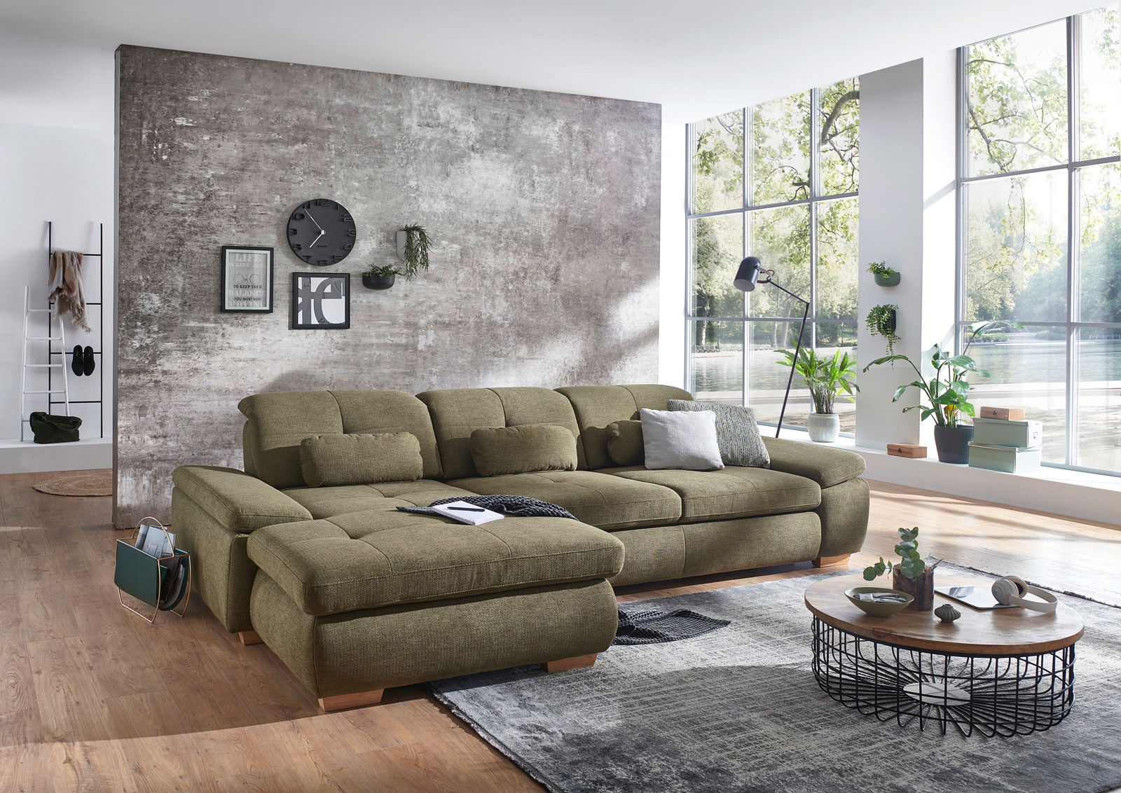 Grüne Longchairkombination in modernem Wohnzimmer mit großen Fenstern und Holzboden, seitliche Perspektive