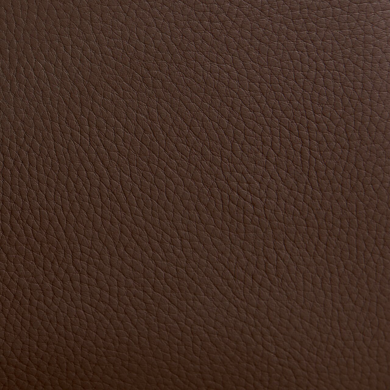 Close-up van een bruine leerstructuur, gebruikt voor een fauteuil.