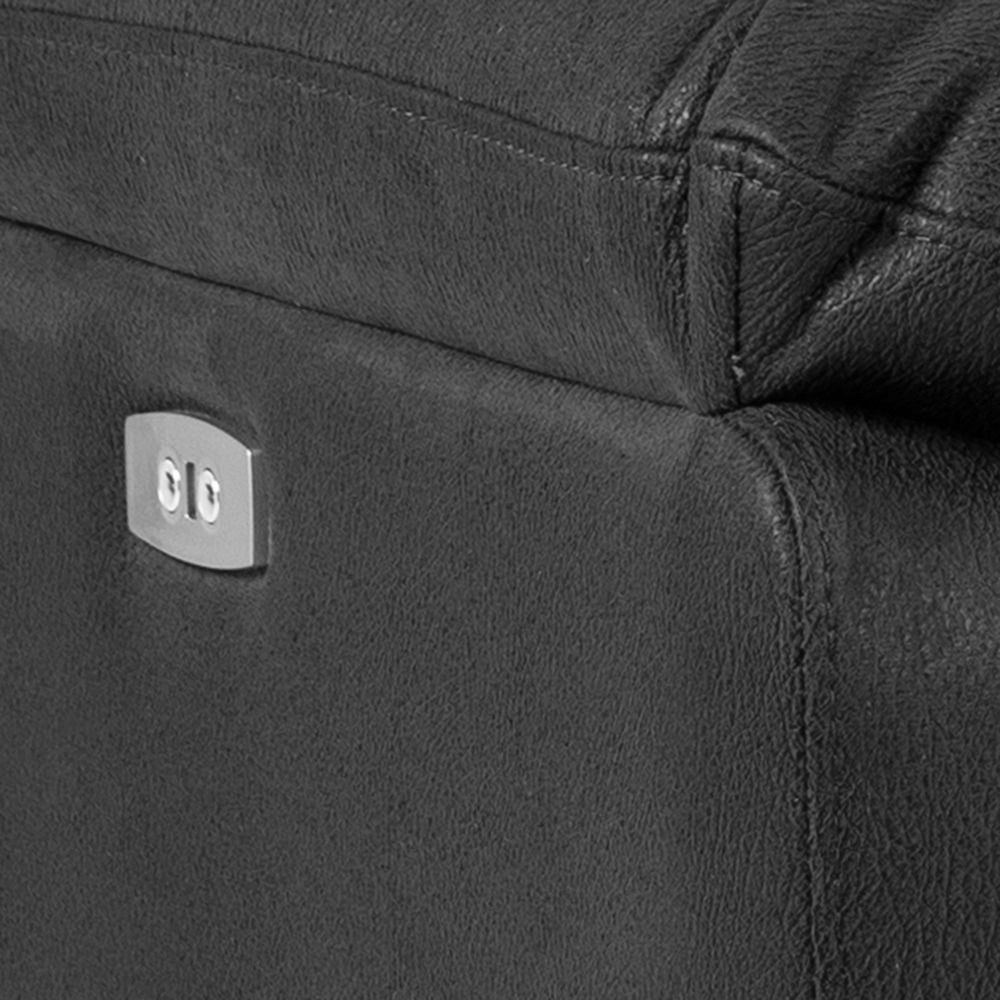 Nahaufnahme eines schwarzen Ledersofas mit einer silbernen Steckdose an der Seite, seitliche Perspektive