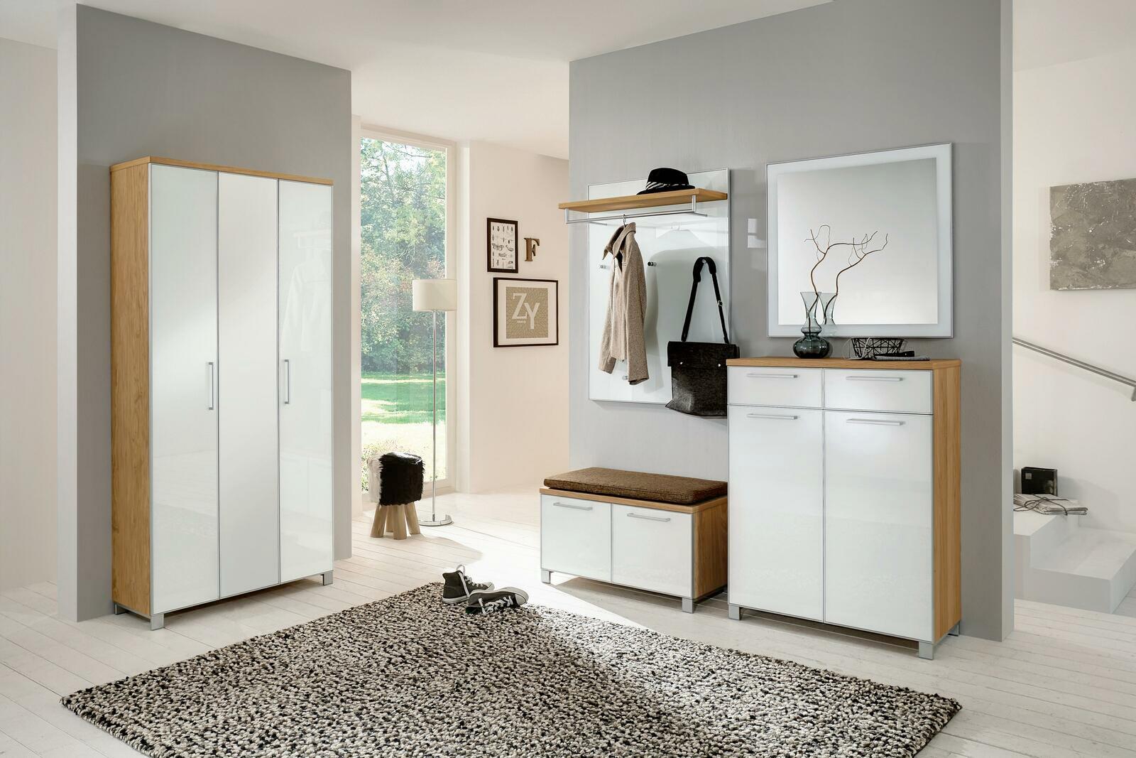 Moderne Garderobeneinrichtung mit weißem Hochglanz-Schuhschrank, Spiegel und Garderobenpaneel in einem hellen Raum, seitliche Perspektive.