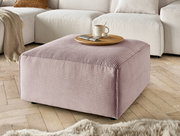 Hocker in rosa Cordstoff, quadratisch, mit einer Tasse und einem Teller darauf, in einem Wohnzimmer mit Holzboden, seitliche Perspektive