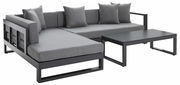 Modernes Lounge-Set mit grauen Kissen und einem schwarzen Tisch, Perspektive von vorne links.