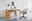 Moderner Drehstuhl mit gepolstertem Sitz und Rückenlehne, in einem minimalistischen Büro mit Holzschreibtisch und Dekorationen, seitliche Perspektive.