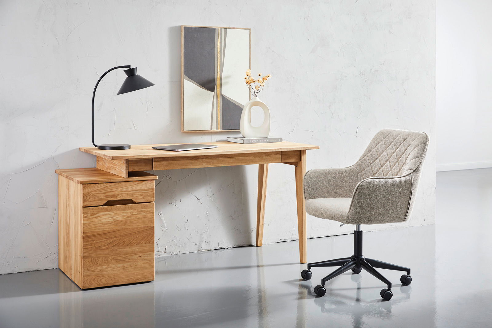 Moderner Drehstuhl mit gepolstertem Sitz und Rückenlehne, in einem minimalistischen Büro mit Holzschreibtisch und Dekorationen, seitliche Perspektive.