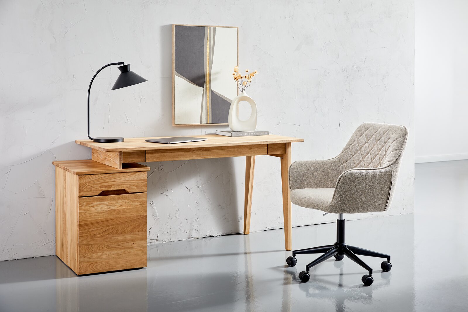 Moderner Drehstuhl mit gepolstertem Sitz und Rückenlehne, in einem minimalistischen Büro mit Holzschreibtisch und Dekorationen, seitliche Perspektive.