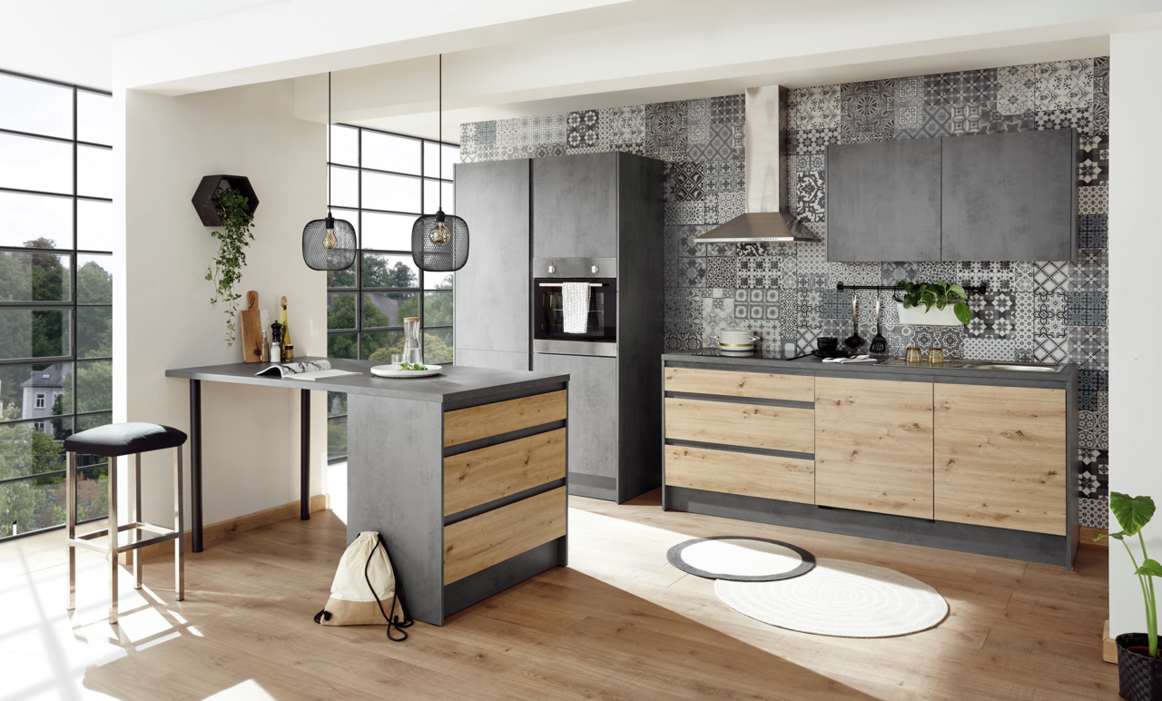 Smartkitchen Kücheninsel TROJA Moderne Kücheninsel in Betonoptik mit Holzschubladen, umgeben von stilvollen Küchenschränken und dekorativen Fliesen, aus der Perspektive eines hellen, lichtdurchfluteten Raumes.