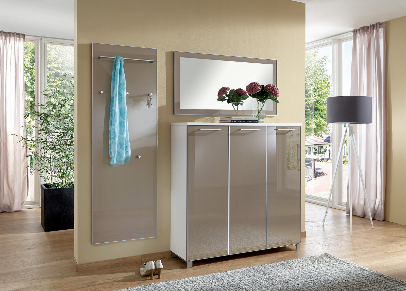 VOSS Garderoben-Set 3-tlg. (Set55) SANTINA Modernes Garderoben-Set bestehend aus einem Spiegel, einem Schrank mit drei Türen und einer Wandgarderobe mit Haken, in einem hellen Raum mit großen Fenstern, aus der Perspektive von vorne betrachtet.