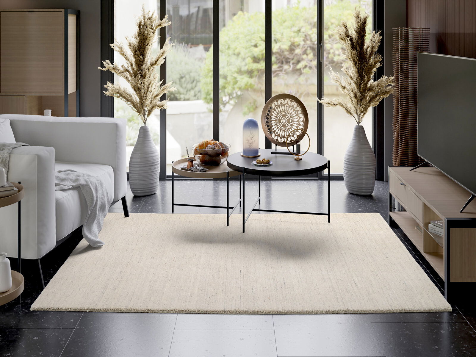 OCI Wollteppich SAMBIA Moderner Wohnraum mit hellem Wollteppich, der zentral im Raum liegt. Der Teppich ergänzt die stilvolle Einrichtung mit einem weißen Sofa, einem runden Couchtisch und dekorativen Vasen. Die Perspektive zeigt den Teppich von oben, wodurch seine Textur und F