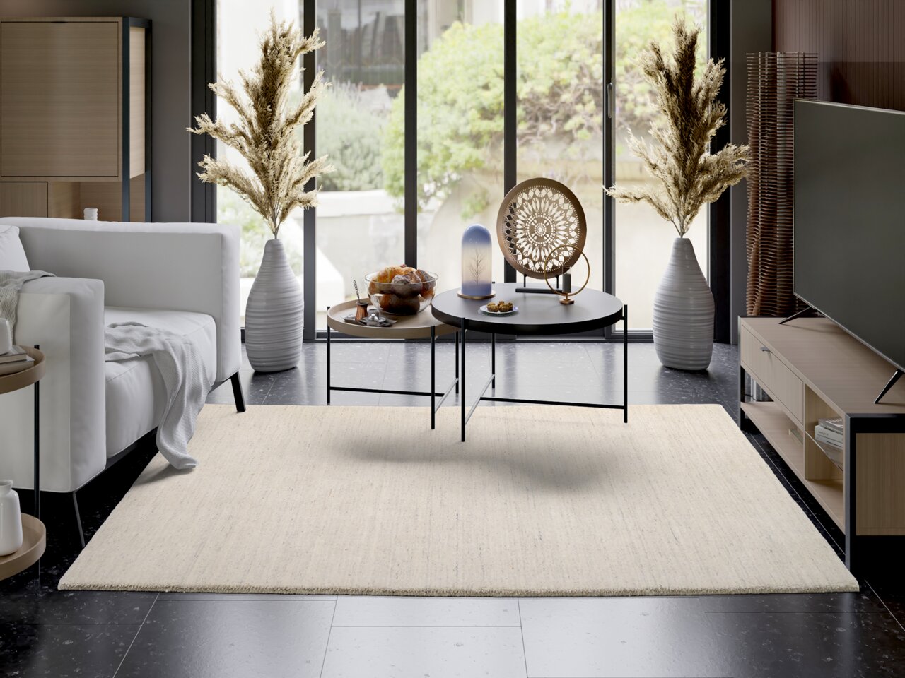 OCI Wollteppich SAMBIA Moderner Wohnraum mit hellem Wollteppich, der zentral im Raum liegt. Der Teppich ergänzt die stilvolle Einrichtung mit einem weißen Sofa, einem runden Couchtisch und dekorativen Vasen. Die Perspektive zeigt den Teppich von oben, wodurch seine Textur und F
