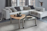 Moderner Couchtisch mit Holz- und Glaselementen, fotografiert aus einer leicht erhöhten Perspektive in einem stilvollen Wohnzimmer.