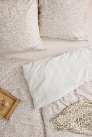 Satinbettwäsche 155x220cm mit dezentem Leopardenmuster in Beige und Weiß, aus der Vogelperspektive fotografiert, mit passendem Kissen und dekorativem Tablett.