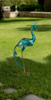 Decoratieve zonne-lamp in de vorm van een blauwe pauw, zijaanzicht op een groen gazon