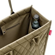 Olivefarbene Einkaufstasche mit Rautenmuster, von oben fotografiert, zeigt eine Flasche in der Seitentasche und ein Reißverschlussfach.