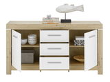 Frontale Ansicht eines modernen Sideboards mit Holzoptik und weißen Türen, dekoriert mit einer Fischskulptur und Büchern.