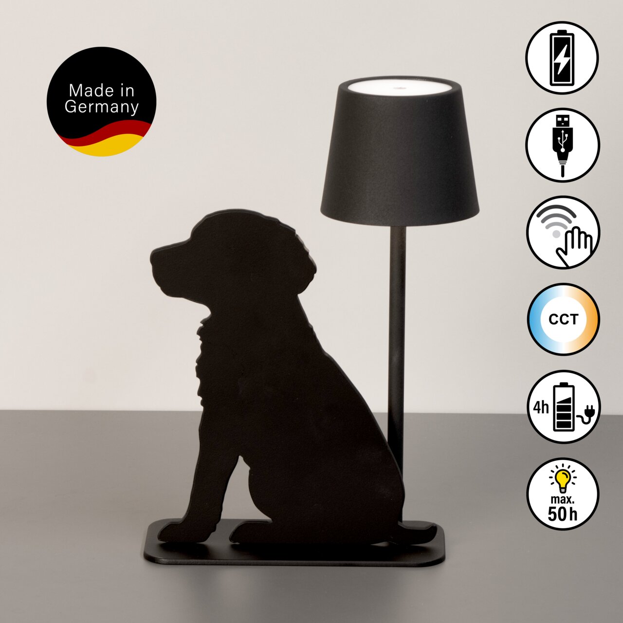 Akku-Tischleuchte mit schwarzer Silhouette eines sitzenden Hundes, seitliche Perspektive. Made in Germany, USB-Anschluss, Touch-Bedienung, CCT-Funktion, 4 Stunden Ladezeit, bis zu 50 Stunden Leuchtdauer.