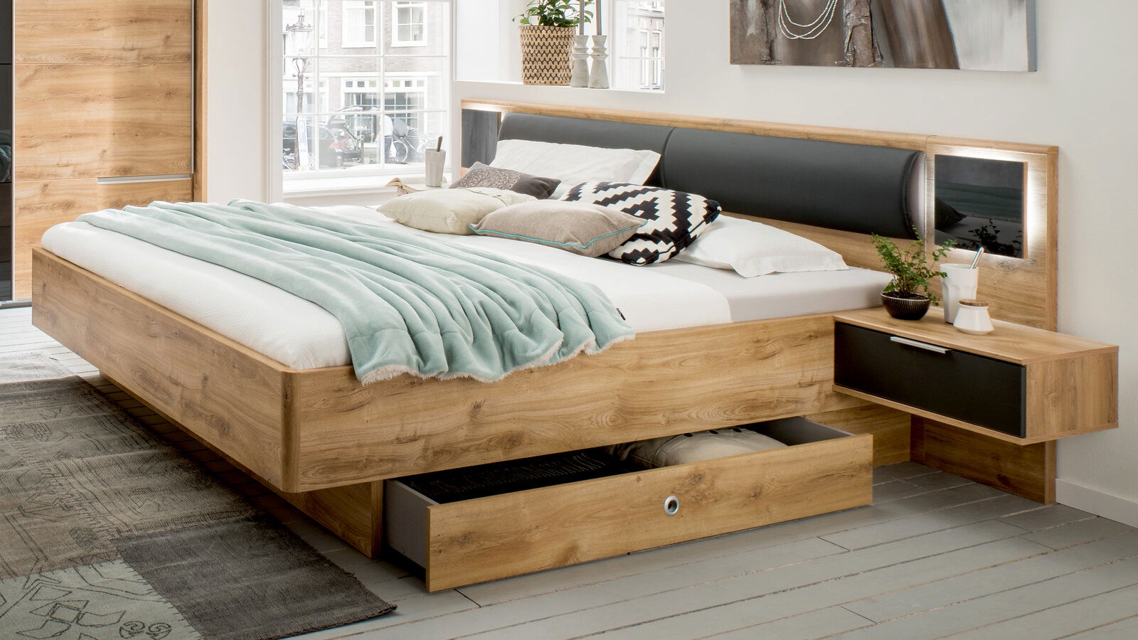 Modernes Holzbett mit integriertem Nachttisch und Schubladen, seitliche Perspektive