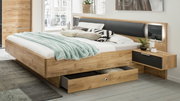 Modernes Holzbett mit integriertem Nachttisch und Schubladen, seitliche Perspektive