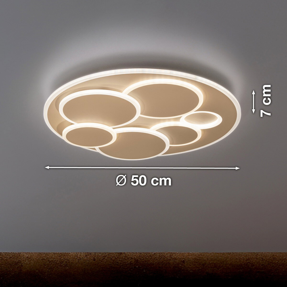 Moderne runde LED-Deckenleuchte in Weiß mit mehreren kreisförmigen Lichtringen, warmweiß leuchtend, Ø 50 cm und 7 cm Höhe, Ansicht schräg von unten (Untersicht) an der Decke