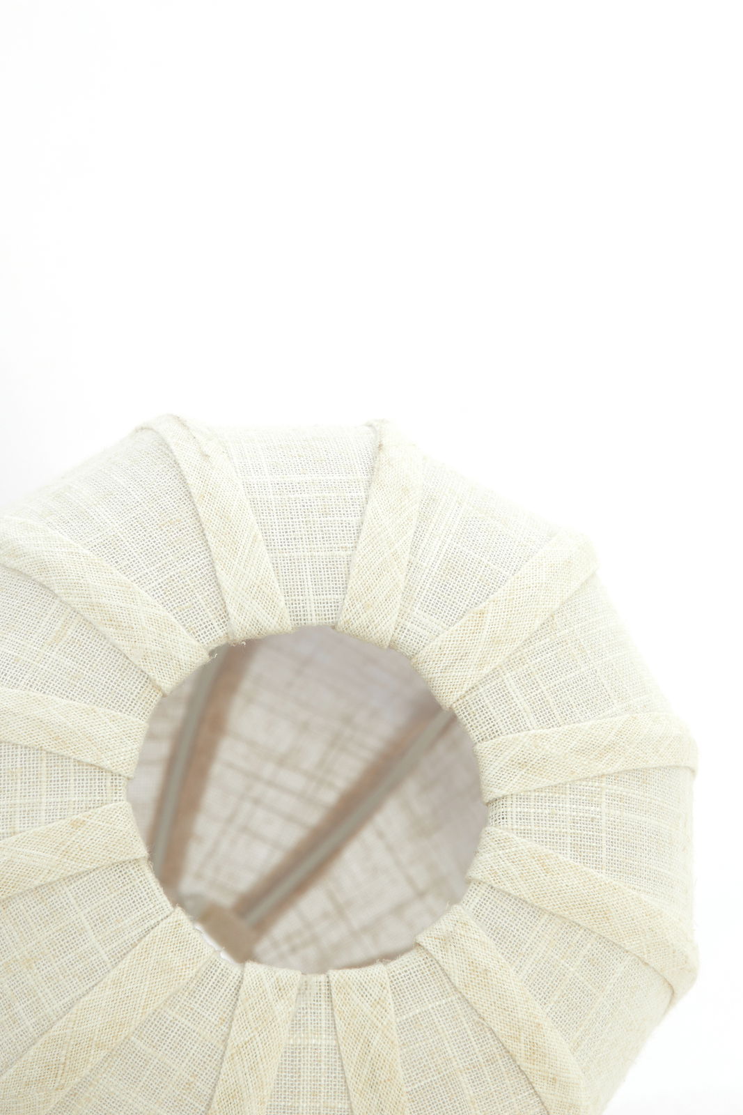 Ansicht von oben auf eine Hängeleuchte mit hellem, texturiertem Stoffschirm.