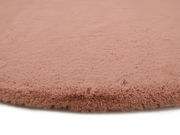 Nahaufnahme eines rosafarbenen Fellteppichs mit weicher, flauschiger Textur.