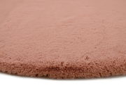 Nahaufnahme eines rosafarbenen Fellteppichs mit weicher, flauschiger Textur.