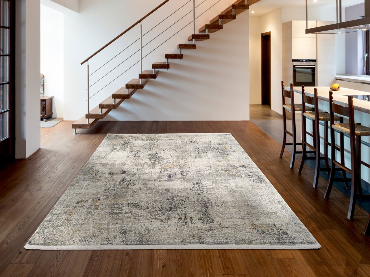 Moderner Designer-Teppich in einem stilvollen Wohnzimmer mit Holztreppe und offener Küche, aus der Vogelperspektive betrachtet.