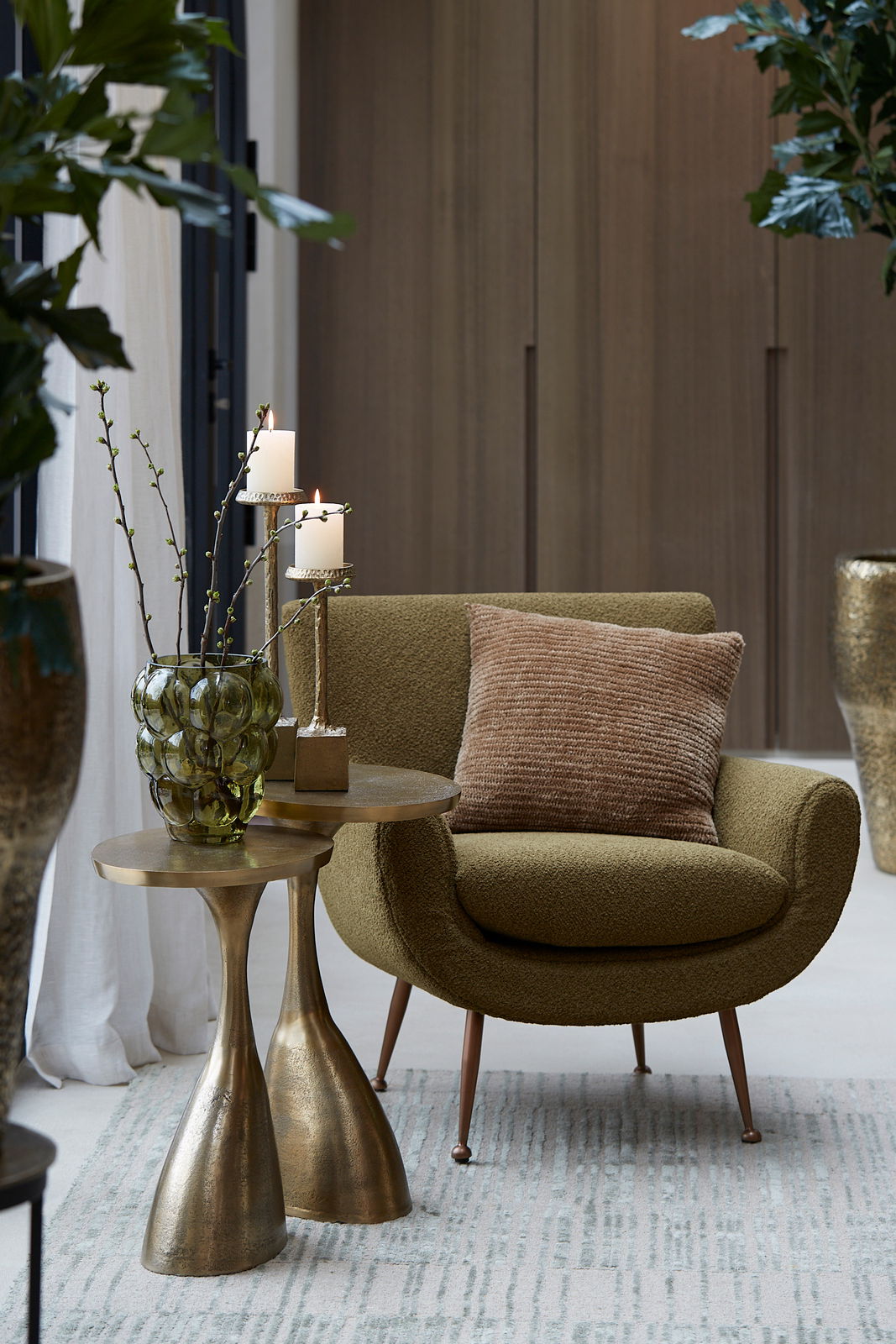 Light&Living Beistelltisch MACAU Beistelltisch mit goldener Oberfläche, dekoriert mit einer grünen Vase und Kerzen, neben einem olivgrünen Sessel, aus seitlicher Perspektive fotografiert.