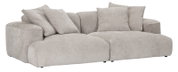 Beiges, modernes Lounge-Sofa mit extra tiefer Sitzfläche, breiten Armlehnen und mehreren Rückenkissen, freigestellt auf weißem Hintergrund, in schräger Frontansicht von links.