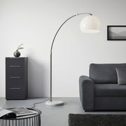 Moderne Bogenleuchte mit weißem Lampenschirm und Marmorsockel, seitliche Perspektive im Wohnzimmer neben einem Sofa und einer Kommode.