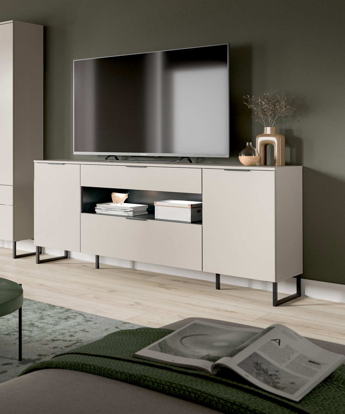 Modernes, hellgraues TV-Lowboard mit schwarzen Metallfüßen und offenen Ablagefächern, darauf ein Flachbildfernseher und Deko; Ansicht schräg von vorn im Wohnzimmer.