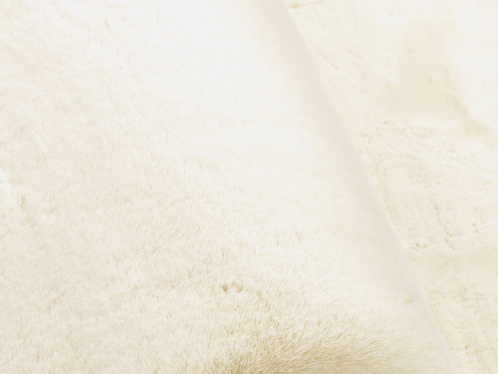 Nahaufnahme eines weißen Fellteppichs mit weicher Textur