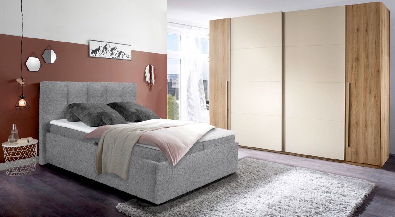 Graues Polsterbett in modernem Schlafzimmer, seitliche Perspektive